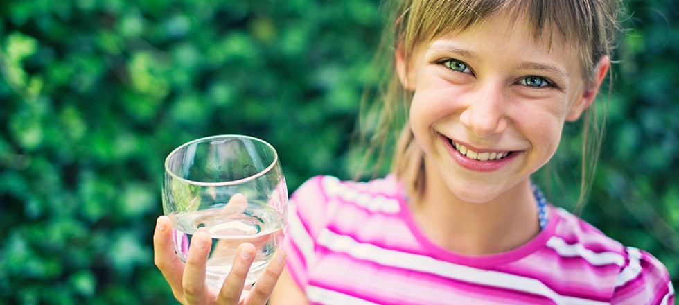 Smiling girl with water glass