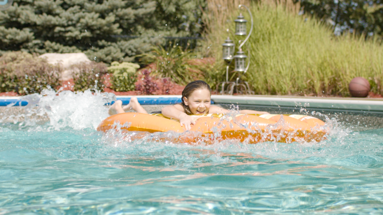 candid shot of girl on floatie in pool splashing around from ham Lake, MN shoot