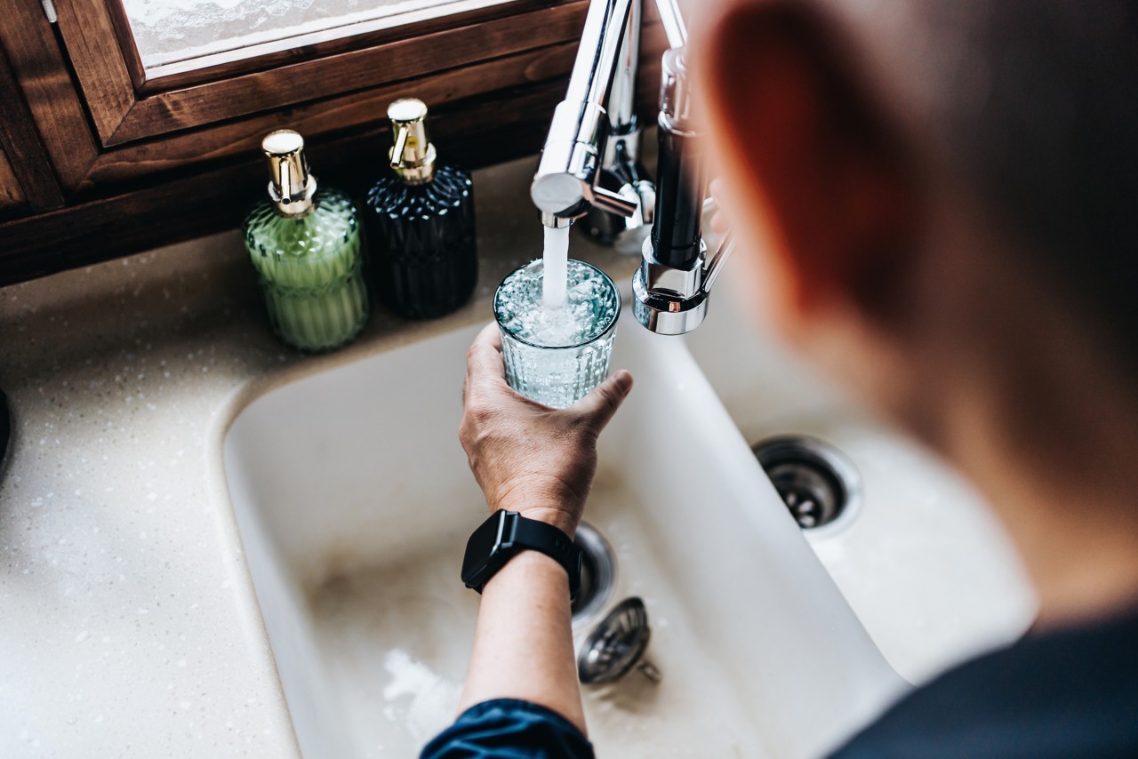 Man pouring himself a glass of water