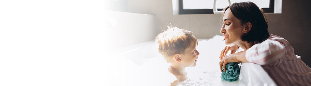 child taking bath while talking to mother